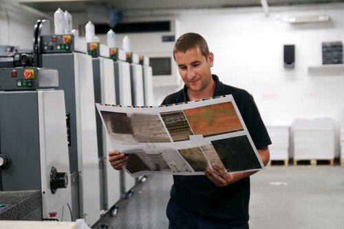 man looking at printed sheet