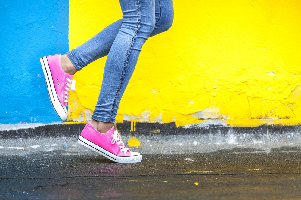woman running past colorful painted wall outside